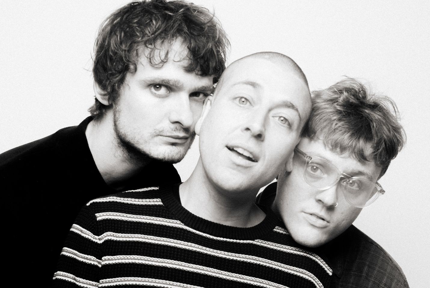 The three members of MOULD with their heads pressed together